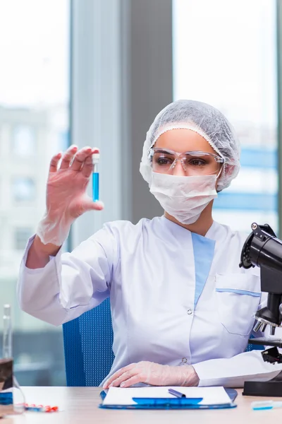 Young student working with chemical solutions in lab