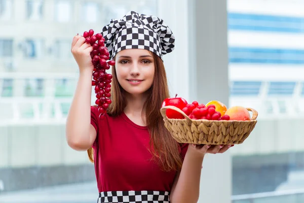 Young cook with fruits in the kitchen