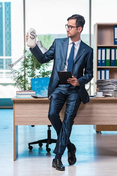 Happy businessman with money sacks in the office