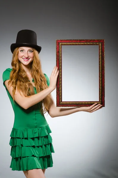 Woman wearing green dress holding picture frame