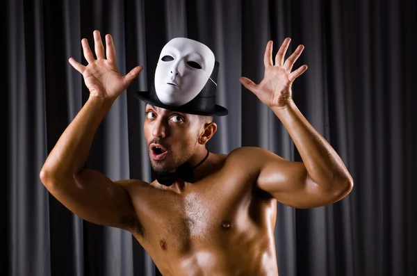 Muscular actor with theatrical mask