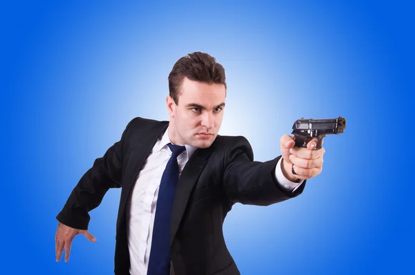 Businessman with gun against the gradient