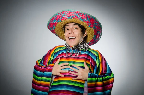 Man in vivid mexican poncho against gray