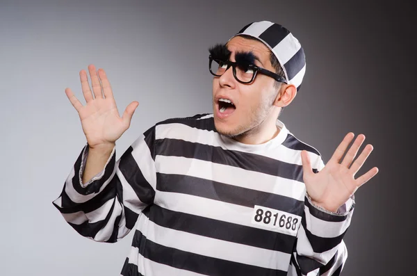Funny prisoner with faked eyebrows in striped uniform