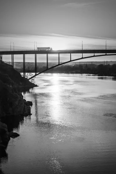 Cargo car goes over the bridge on the background of the beautiful sky