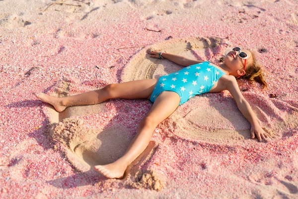 Girl making sand angel