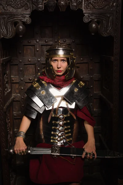 Beautiful woman in roman helmet and armour