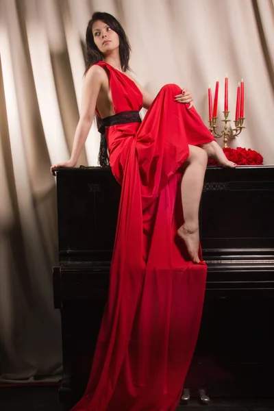 Fashionable brunette in a long red dress