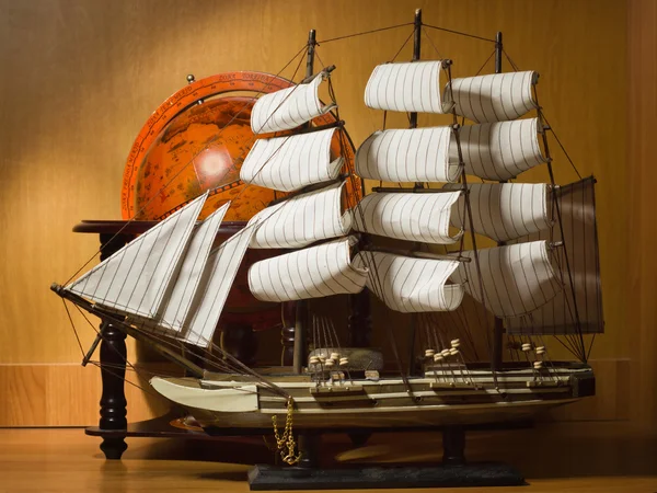 Model sailing ship and old globe