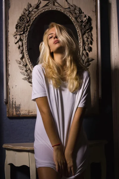Hot woman in white t-shirt posing in gothic interior