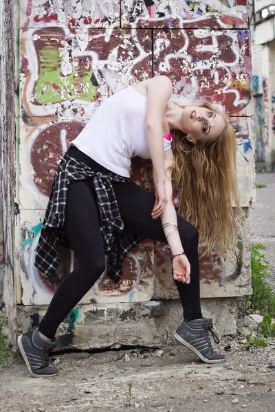 Young woman dancer on graffiti background