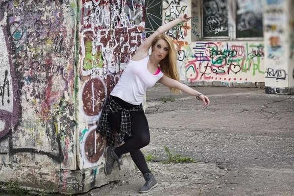 Young woman dancer on graffiti background