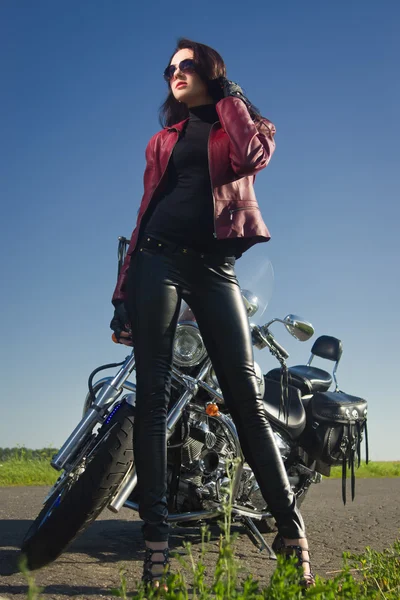 Biker girl in a leather jacket on a motorcycle