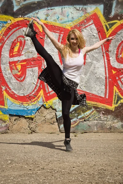 Young girl dancing on graffiti background