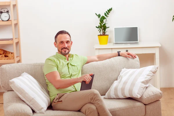 Handsome man using tablet PC at home