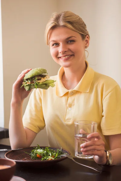 Woman eating vegan burger in restaurant