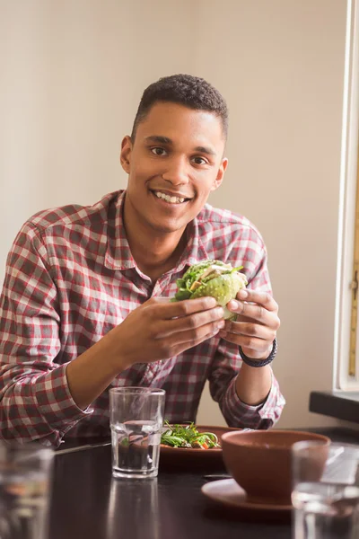 Man eating vegan burger in restaurant