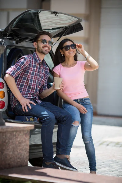 Happy tourist man and woman in car