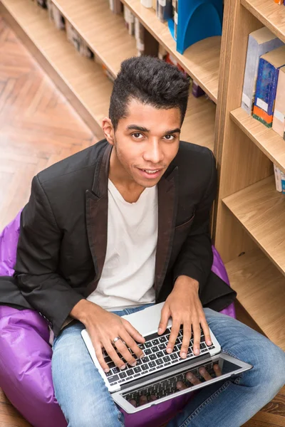Handsome man with laptop computer in library