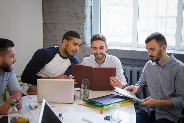 Businessmen sitting round table in board room in office