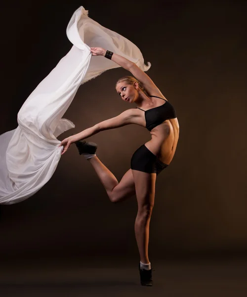 Beautiful woman in motion holding fabric