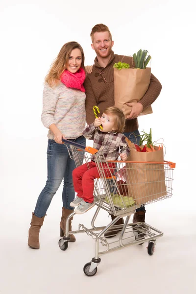 Happy couple and baby in shopping cart