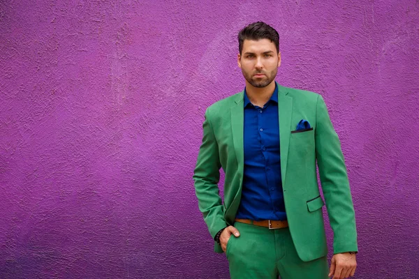 Man in green suit and blue shirt looking at camera