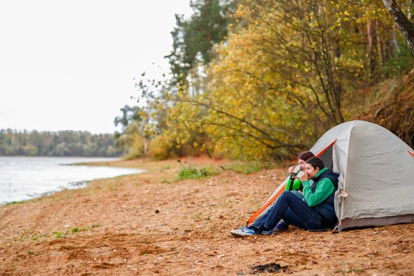 Woman and man sitting near tent