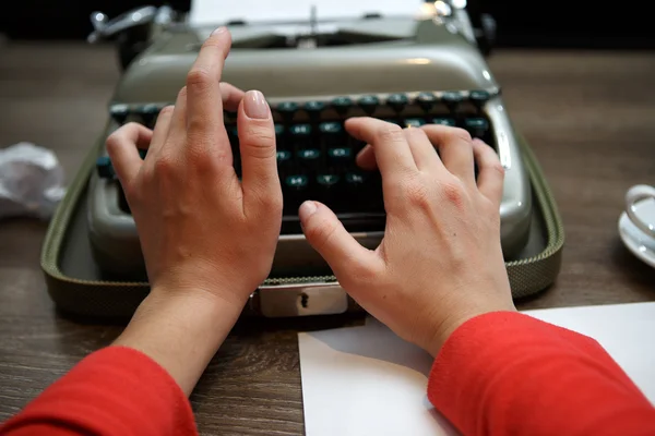 Woman typing on old typewriter