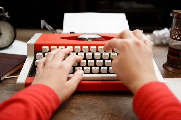 Vintage red typewriter with blank paper