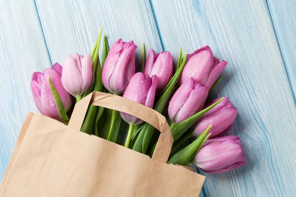 Fresh pink tulip flowers in paper bag