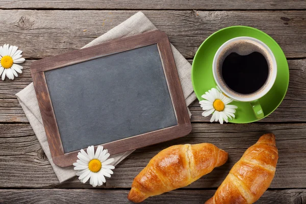 Blackboard, croissants and coffee cup