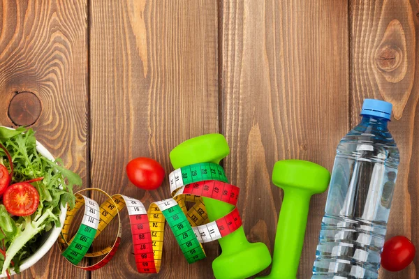 Dumbbells, tape measure and healthy food.