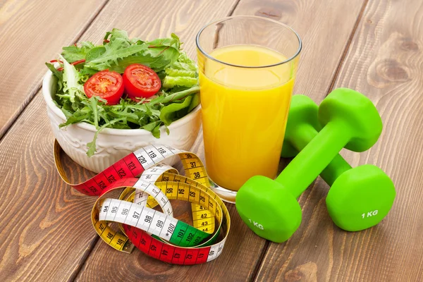 Dumbbells, tape measure and healthy food.