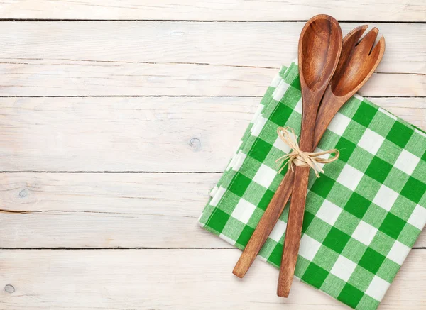 Kitchen utensils over white wooden table background