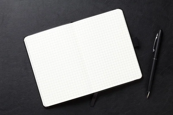 Notepad and pen on office leather desk