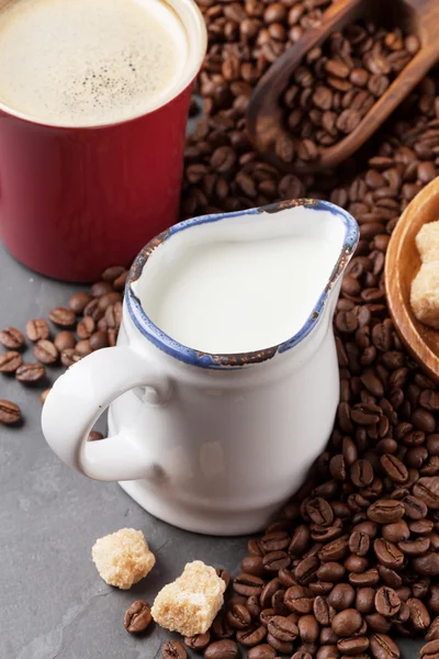 Milk jug, coffee cup and beans