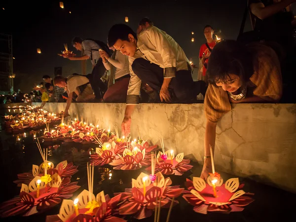 People float lanterns in the river