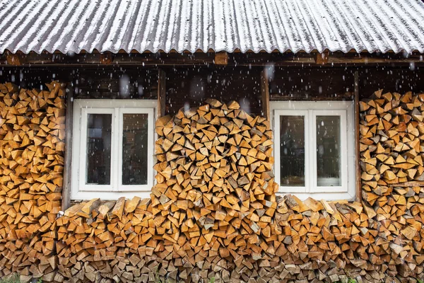 Windows of a traditional country cottage house with firewood log