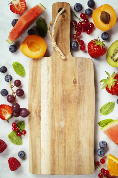 Old cutting board, Watermelon, fruits, berries and mint leaves.