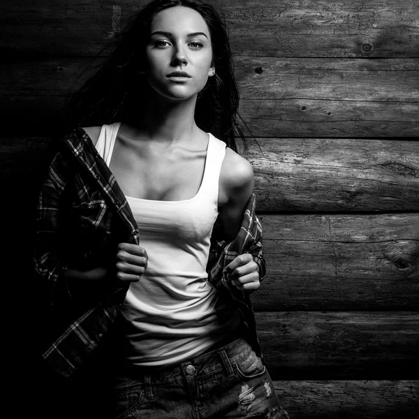 Young sensual & beauty woman in casual clothes pose on grunge wooden background. Black-white fashion photo.