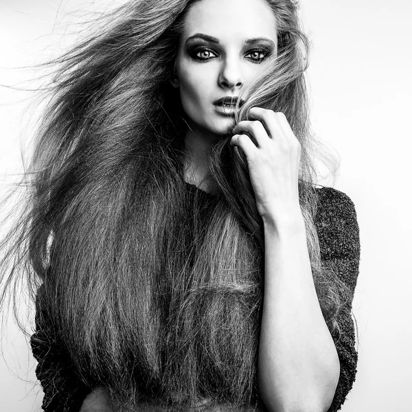 Black-white portrait of beautiful young woman with magnificent long hairs.