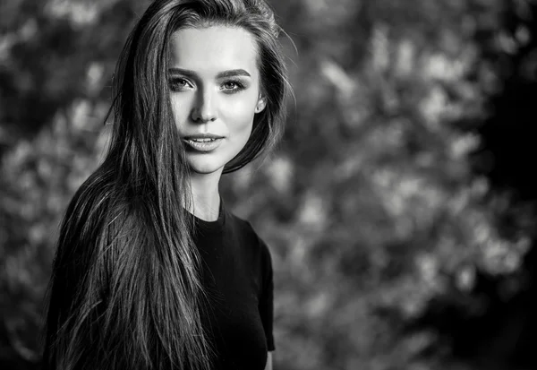 Outdoors black-white portrait of beautiful young long hair brunette woman