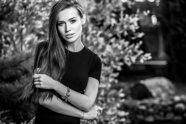 Outdoors black-white portrait of beautiful young long hair brunette woman