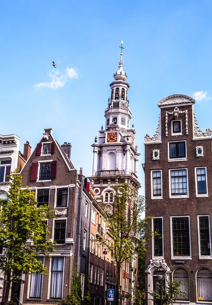 AMSTERDAM, NETHERLANDS - AUGUST 6, 2016: Famous buildings of Amsterdam city centre close-up. General landscape view of city streets and traditional Dutch architecture. Amsterdam - Netherlands.