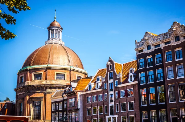AMSTERDAM, NETHERLANDS - AUGUST 15, 2016: Famous buildings of Amsterdam city centre close-up. General landscape view of city streets and traditional Dutch architecture. Amsterdam - Netherlands.
