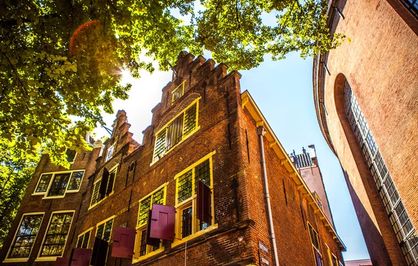 AMSTERDAM, NETHERLANDS - AUGUST 15, 2016: Famous buildings of Amsterdam city centre close-up. General landscape view of city streets and traditional Dutch architecture. Amsterdam - Netherlands.