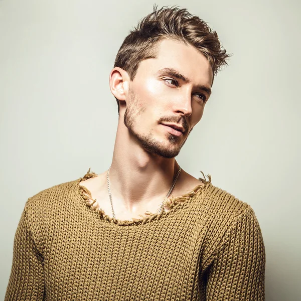 Studio portrait of young handsome man in knitted sweater. Close-up photo.