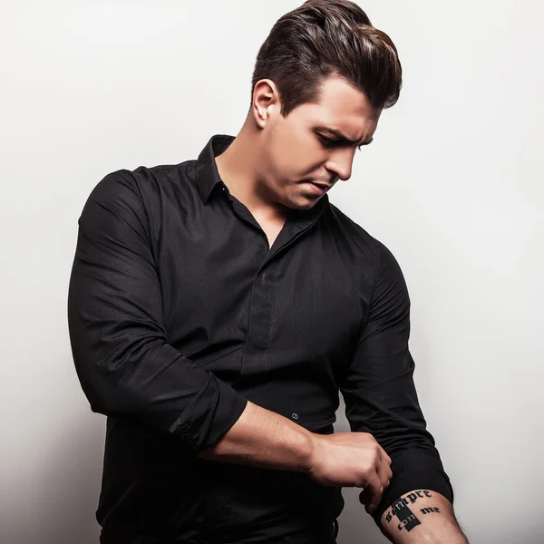 Studio portrait of young handsome man in black shirt. Close-up photo.