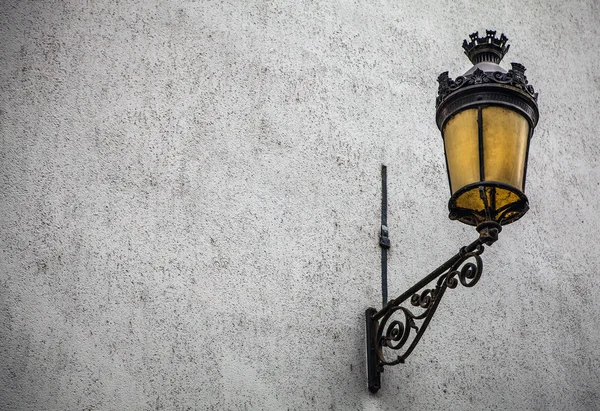 Ancient street lamp on stone wall